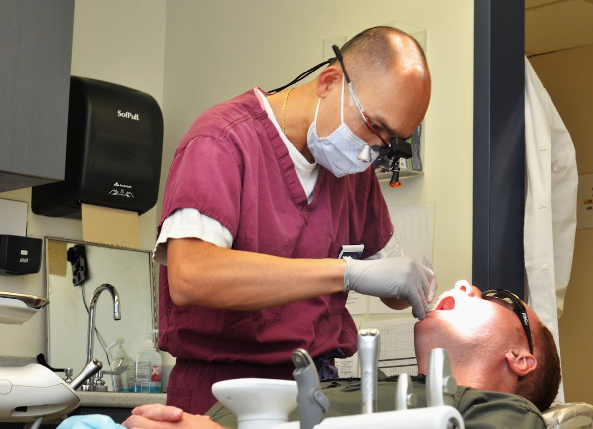 Dentist examining a patient's teeth in a clinic — Extractions & Minor Surgery at Hooper, Too Family Dentistry