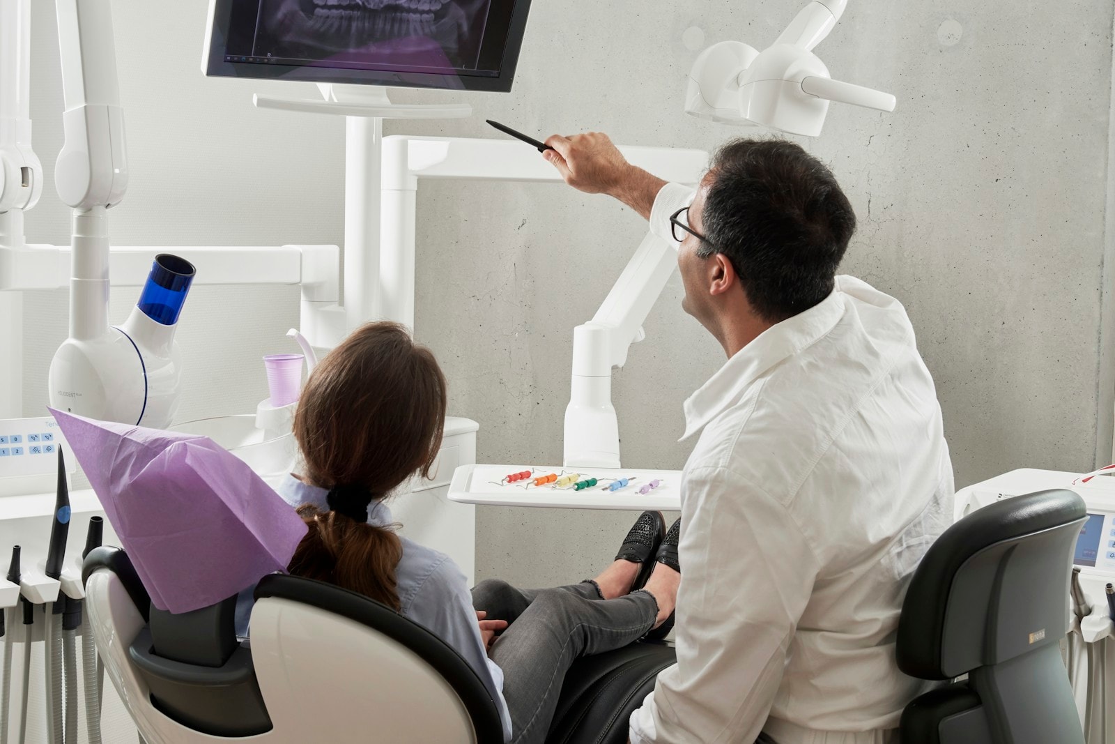 Dentist showing a panoramic dental X-ray to a patient during consultation — Root Canals at Hooper, Too Family Dentistry